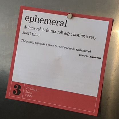 A picture of a page from a tearaway calendar, with a magnet affixing it to a metallic surface. The page, for Friday, March 3rd, 2024, reads: 'ephemeral', /i-ˈfem-rəl, i-ˈfe-mə-rəl/, adj: lasting a very short time. The young pop star's fame turned out to be ephemeral. This text is followed by the words 'Did you know?', with an right-facing arrow after them, indicating something, unseen, on the backside of the page.